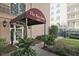 The Barcelona building entrance with a covered entryway, attractive outdoor lighting, and verdant landscape at 395 Pharr Ne Rd # 103, Atlanta, GA 30305