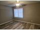 Bedroom with neutral walls and wood-look floors, complemented by a ceiling fan and natural light at 5818 Par Four Ct, Lithonia, GA 30038