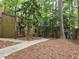 Exterior view of brown buildings set amongst tall trees and foliage, including a concrete walkway at 5818 Par Four Ct, Lithonia, GA 30038