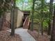 Exterior view of a brown two-story home surrounded by lush greenery and a walkway to the front door at 5818 Par Four Ct, Lithonia, GA 30038