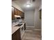 Galley kitchen with wood cabinets, white appliances, modern subway tile backsplash, and wood-look flooring at 5818 Par Four Ct, Lithonia, GA 30038