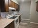 Galley kitchen with wood cabinets, white appliances, modern subway tile backsplash, and wood-look flooring at 5818 Par Four Ct, Lithonia, GA 30038