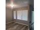 Living room showcasing large windows, modern gray walls, and wood-look floors at 5818 Par Four Ct, Lithonia, GA 30038