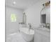 An elegant bathroom featuring marble countertops, dual sinks, and a luxurious soaking tub beneath an arched window at 833 Martina Ne Dr, Atlanta, GA 30305