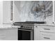 Gourmet kitchen featuring stainless steel range, modern pot filler, and luxurious marble backsplash at 833 Martina Ne Dr, Atlanta, GA 30305