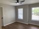 This bedroom features a modern ceiling fan, natural light from two windows, and wood-look flooring at 219 Maple Creek, Woodstock, GA 30188