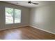 Well-lit bedroom with wood-look flooring and a large window showcasing a lovely neighborhood view at 219 Maple Creek, Woodstock, GA 30188