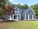 Inviting two-story home with gray siding, lush landscaping, and a cozy front porch entrance at 219 Maple Creek, Woodstock, GA 30188