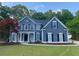 Charming two-story home featuring blue siding, black shutters, manicured lawn, and welcoming front entrance at 219 Maple Creek, Woodstock, GA 30188