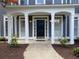 Welcoming front porch with white columns, a dark front door, and neat landscaping at 219 Maple Creek, Woodstock, GA 30188