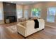 Bright living room featuring hardwood floors, a cozy fireplace, and an area rug at 219 Maple Creek, Woodstock, GA 30188