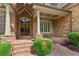 Welcoming front porch with brick and stone details, double doors, and beautiful wreaths at 3341 Anna Ruby Ln, Buford, GA 30519