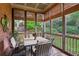 Inviting screened-in porch with beautiful views, a dining table, and wicker blinds for shade at 3341 Anna Ruby Ln, Buford, GA 30519