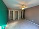 A carpeted bedroom with ceiling fan with multiple closet doors and walls painted in contrasting neutral tones at 3709 Charlotte Dr, Rex, GA 30273