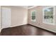 Well-lit bedroom with hardwood floors, neutral walls, and a door to the hallway at 4615 Thermal Ct, Douglasville, GA 30135