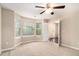 A well-lit living room featuring neutral carpeting, a ceiling fan, and a view of the front yard at 4615 Thermal Ct, Douglasville, GA 30135