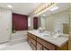 Bright bathroom with double vanity, a separate soaking tub, and decorative wallpaper at 670 Dena Dr, Canton, GA 30114