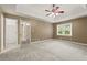 Expansive main bedroom with tray ceilings, plush carpet, ceiling fan, natural lighting, and closet at 670 Dena Dr, Canton, GA 30114