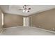 Large Primary bedroom showcasing a tray ceiling, ceiling fan, plush carpet, and closet access at 670 Dena Dr, Canton, GA 30114