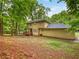 View of home's backyard and wooden deck surrounded by beautiful trees at 8683 Twin Oaks Dr, Jonesboro, GA 30236