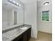 Bright bathroom features a granite countertop, vanity and large mirror and window at 8683 Twin Oaks Dr, Jonesboro, GA 30236