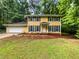 Charming two-story home with yellow siding, dark shutters, and a well-manicured lawn at 8683 Twin Oaks Dr, Jonesboro, GA 30236