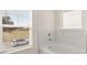 Bright bathroom featuring soaking tub with marble tile surround and view at 1288 Hollingsworth Way, Dacula, GA 30019
