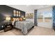Stylish bedroom showcasing a dark accent wall, decorative pictures, and natural light from a window at 1288 Hollingsworth Way, Dacula, GA 30019