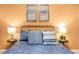 Inviting bedroom featuring a metal frame bed with blue bedding and warm lighting at 1288 Hollingsworth Way, Dacula, GA 30019
