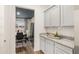 Butler's pantry with granite counters, gray cabinets, and views to the dining area offers additional storage space at 1288 Hollingsworth Way, Dacula, GA 30019