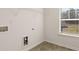 Functional laundry room with utility connections, shelving, and a window for natural light at 1288 Hollingsworth Way, Dacula, GA 30019