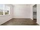 Open living room with hardwood floors and white trim; view of kitchen cabinets at 1288 Hollingsworth Way, Dacula, GA 30019