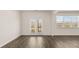 Bright living room featuring hardwood floors, white trim, and glass doors to outdoor balcony at 1288 Hollingsworth Way, Dacula, GA 30019