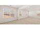 Bright living room features neutral carpet, recessed lighting, and large windows at 1288 Hollingsworth Way, Dacula, GA 30019