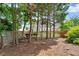 View of the backyard through the trees, showcasing the privacy fence and lush landscaping at 1294 Parkview Nw Ln, Kennesaw, GA 30152