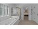 Bright bathroom featuring a soaking tub, walk-in shower, and access to the main bedroom at 1294 Parkview Nw Ln, Kennesaw, GA 30152