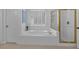 Bright, white bathroom with tub, tiled surround, and a shower with a gold frame at 1294 Parkview Nw Ln, Kennesaw, GA 30152