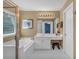 Bathroom with a soaking tub, white vanity, and decorative lighting fixtures at 1294 Parkview Nw Ln, Kennesaw, GA 30152