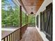 Relaxing back porch with natural wood columns and ceiling overlooking the wooded backyard at 210 Joe Green Ln, Canton, GA 30114