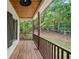 Inviting back porch featuring stained wood ceiling, black light fixture and dark window shutters at 210 Joe Green Ln, Canton, GA 30114
