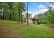 Lush backyard with mature trees surrounding a cozy home with a screened porch at 210 Joe Green Ln, Canton, GA 30114