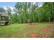 Beautiful backyard with lush green grass and a home with a porch in the distance at 210 Joe Green Ln, Canton, GA 30114