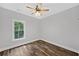 Cozy bedroom with ceiling fan, wood-look floors, a framed window, and light gray walls at 210 Joe Green Ln, Canton, GA 30114