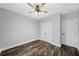 Bedroom features a ceiling fan, wood-look floors, light gray walls, and double-door closet at 210 Joe Green Ln, Canton, GA 30114