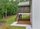 Exterior view of the home's screened porch, stairs and back yard area surrounded by trees at 210 Joe Green Ln, Canton, GA 30114