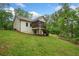 Green backyard with home in the background featuring a porch and walkout basement at 210 Joe Green Ln, Canton, GA 30114