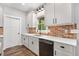Modern kitchen features white cabinets, quartz countertops, brick backsplash, and stainless steel dishwasher at 210 Joe Green Ln, Canton, GA 30114