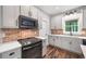 Well-lit kitchen with gray cabinets, quartz countertops, brick backsplash, and modern appliances at 210 Joe Green Ln, Canton, GA 30114