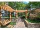 Charming courtyard with a swing bench under a wooden pergola, enhanced by stone walls and manicured greenery at 2110 River Green Nw Dr # 2110, Atlanta, GA 30327