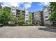 Beautiful condo building exterior with lush landscaping, balconies, and a paved parking area at 2110 River Green Nw Dr # 2110, Atlanta, GA 30327